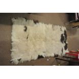 COLLECTABLES - A large sheepskin rug.