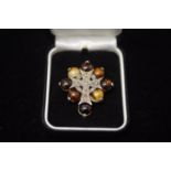 AMBER-STYLE BROOCH WITH METAL CROSS. MARKED MIRACLE.