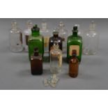 TWELVE MISMATCHING GLASS MEDICINE BOTTLES, PLUS A SMALL SELECTION OF SPARE GLASS STOPPERS