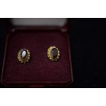 GOLD STUD EARRINGS SET WITH GARNETS.