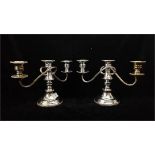A pair of silver plated on copper three light candlesticks, ornate knopped stem on stepped