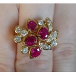 An 18ct gold, ruby and diamond cluster ring, set with four pear shaped rubies and brilliant cut