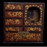 A Japanese miniature lacquer cabinet of six drawers, with 'secret' larger box drawer behind lift