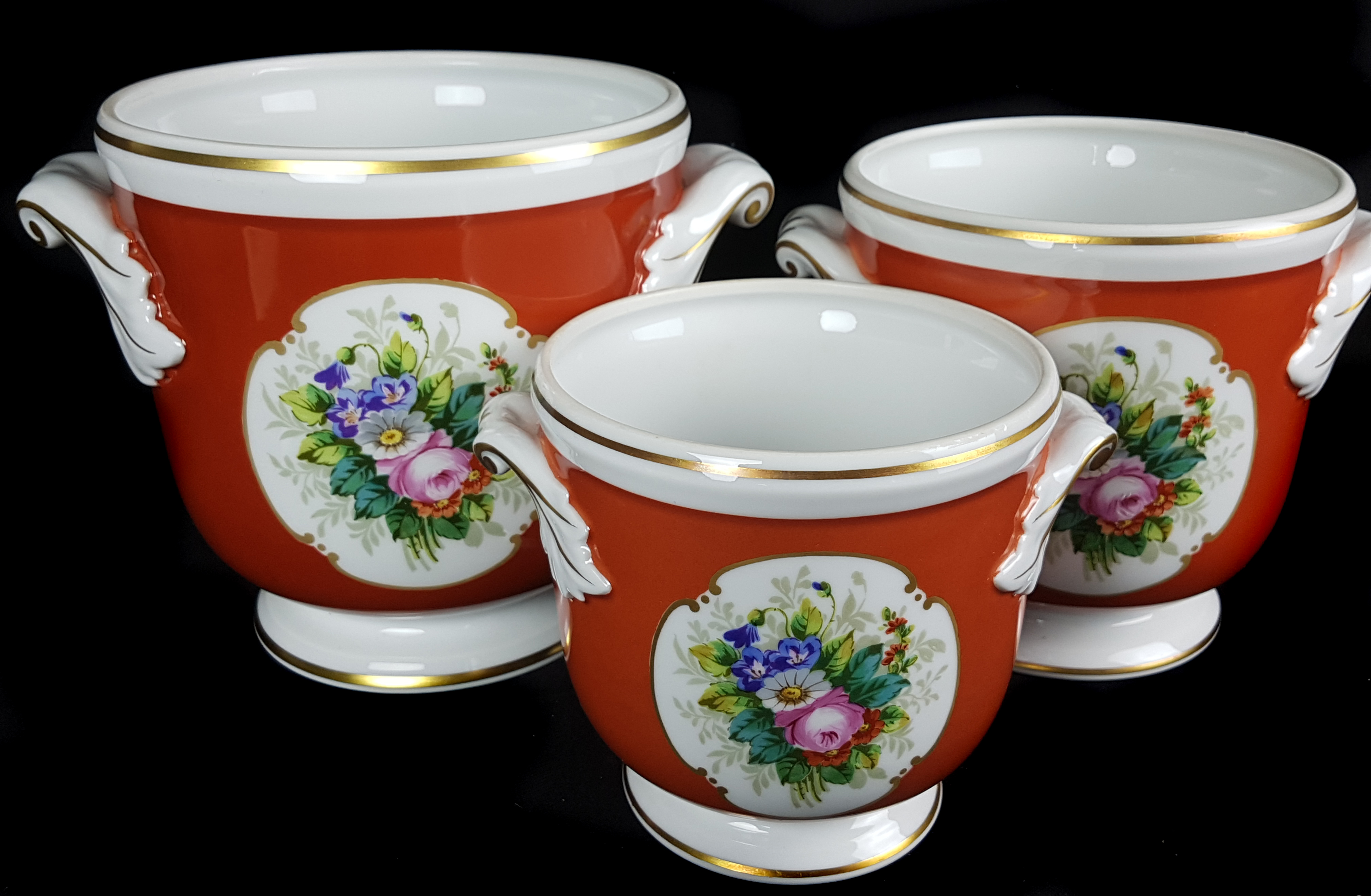 A graduated set of three Vista Alegre porcelain cache pots, painted with reserves of summer