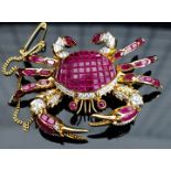 A diamond and ruby articulated crab form brooch, the body invisibly set with rubies, in yellow