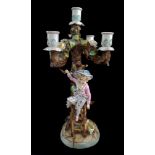 A German porcelain five light candelabra, modelled as a young boy climbing a ladder to pick apples