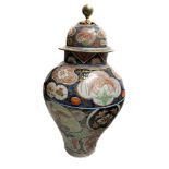 A large pair of Japanese Imari vases and covers, ovoid with domed covers, painted with reserves of