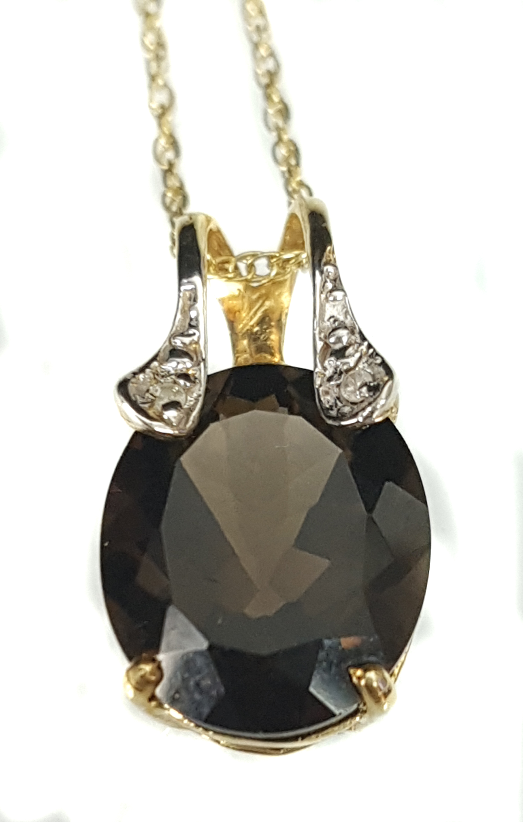 A chocolate topaz and diamond pendant set with two small diamond chips in 9ct yellow gold mount;