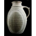 A large studio pottery cider jug, marked AW beneath handle, to bodycovered with grey drip glaze