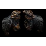 A pair of Chinese carved wood Dogs of Fo, each with paw resting on a pierced ball, 26cm high (2)