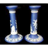 A pair of Wedgwood etruria mark dark blue jasper candlesticks, sprigged with classical motifs,