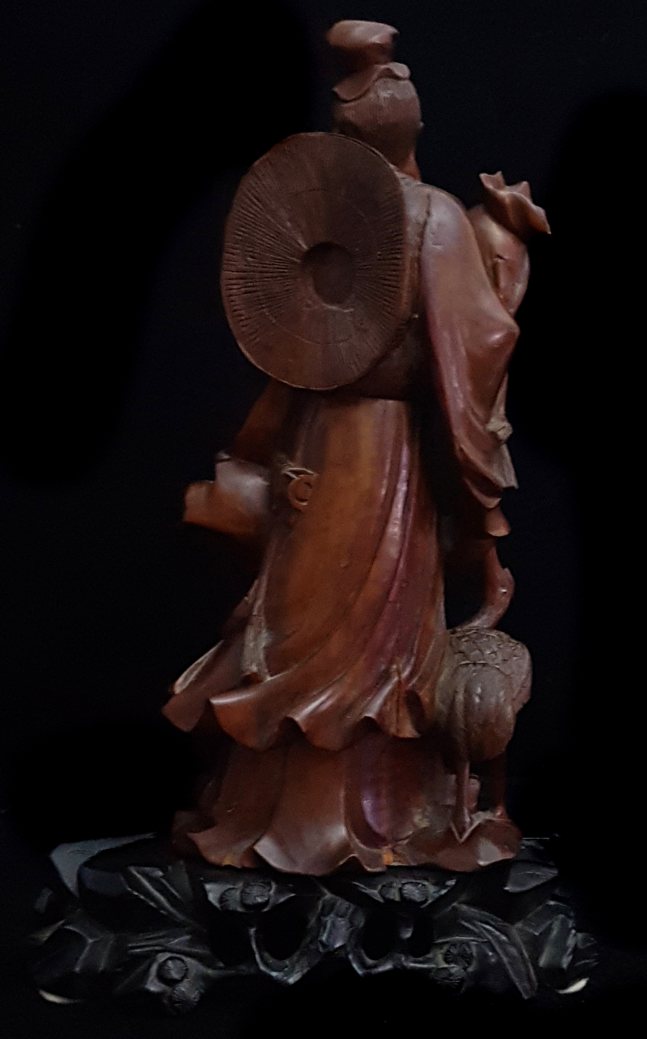 A Chinese bamboo carving of an immortal holding a large wrapped scroll, a crane to one side, eyes - Image 2 of 3