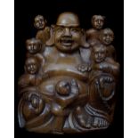 A Chinese carved wood Buddha, encircled by seven smaller figures, 24cm high