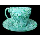 A Tosso brothers millifiori glass teacup and saucer, green and blue canes with red centres on a whit