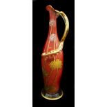 Harrach - a Bohemian red marble glass jug, of slender bottle form, gilded and enamelled with