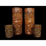 Two pairs of Chinese carved bamboo brush stands, decorated with figures in landscapes, 29cm high;