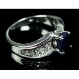 A diamond and sapphire white gold ring, the main oval sapphire of 1ct, mid opaque-deep blue colour