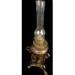 A Victorian scrolled brass and copper oil lamp, on trefoil base with lion pad feet, the oil bowl