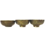 Three Islamic brass bowls, chased with panels of Islamic or Arabic script within strapwork with