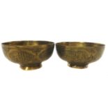 A pair of Islamic brass bowls, chased with panels of Islamic or Arabic script within strapwork