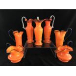 Tango Glass - Seven bright orange glass jugs, of various shapes, trailed in blue, 25cm high (7)