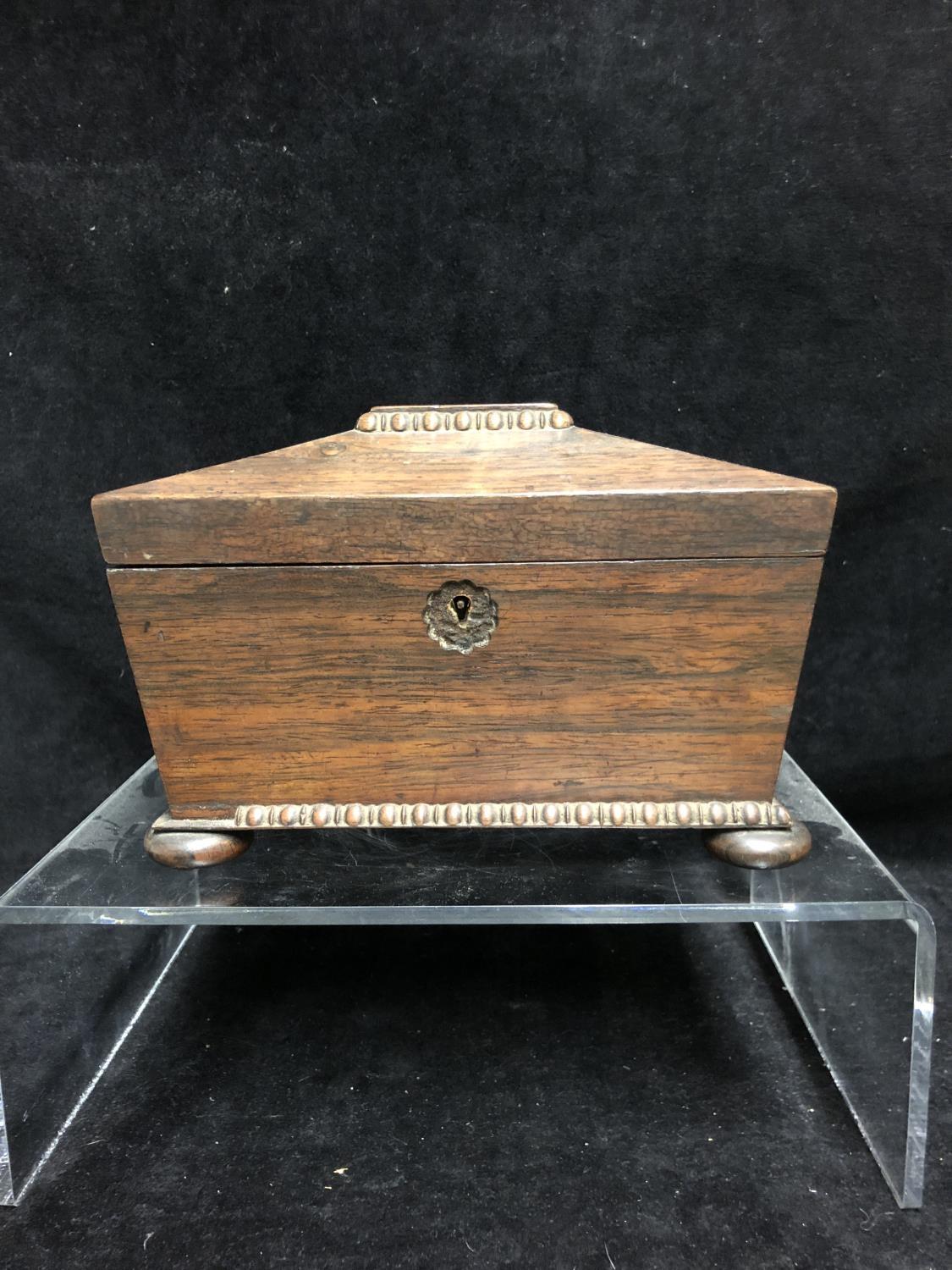 A Rosewood sarcophagus form tea caddy, egg and dart carved details, on four flat bun feet, 21cm max