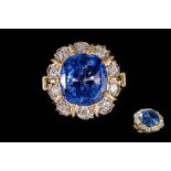 A SAPPHIRE AND DIAMOND CLUSTER RING, with one cushion cut sapphire of 7.