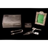 A PRE-WAR SILVER CIGARETTE BOX, Birmingham 1933; together with a silver match box, photo frame,