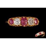 A VICTORIAN RUBY AND DIAMOND CARVED DRESS RING, with three cushion cut rubies of approx. 0.