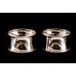 A PAIR OF GEORGE V SILVER NAPKIN RINGS, with beaded edge decoration, Birmingham 1924,