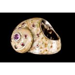 A SPIRAL SHELL RING, set with garnets an