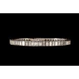 A DIAMOND LINE BRACELET, set throughout with rectangular step cut diamonds of approx. 12.