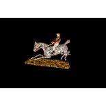 A DIAMOND PAVÉ HORSE AND JOCKEY BROOCH, with red, green and white enamel finish.