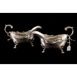 A MODERN PAIR OF SILVER SHAPED HELMET SAUCE BOATS, egg and dart rim, scroll handle,