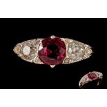 A RUBY AND DIAMOND CARVED THREE STONE RING, with one cushion cut ruby of 1.