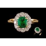 AN EMERALD AND DIAMOND CLUSTER RING, with emerald of approx. 1.