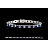 A SAPPHIRE AND DIAMOND LINE BRACELET, set throughout with square step cut sapphires of 16.