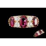 A RUBY AND DIAMOND CARVED DRESS RING, with three cushion cut rubies of 2.
