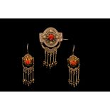 A CORAL AND GOLD COMPOSITE SUITE, comprising of earrings and a brooch, in antique case,