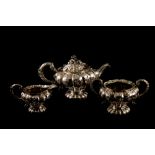 A GEORGE IV SILVER THREE PIECE TEA SET, of naturalistic form, chased and engraved,