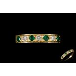 AN EMERALD AND DIAMOND SEVEN STONE RING,