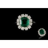 AN EMERALD AND DIAMOND CLUSTER RING, one step cut emerald of 2.
