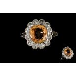 AN ORANGE SAPPHIRE AND DIAMOND CLUSTER RING, one cushion cut orange sapphire of 3.