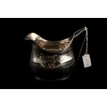 A GEORGE III SILVER MILK JUG, with chased and engraved decoration,