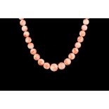 A GRADUATED CORAL BEAD NECKLACE, 67 round beads, from 9.0mm - 14.