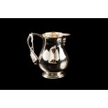 A GEORGE V SILVER MILK JUG, of plain baluster form, 3" high, London 1924,