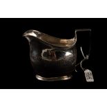 A GEORGE III SILVER MILK JUG, with chased and engraved decoration,