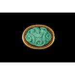A 19TH CENTURY CARVED TURQUOISE CABOCHON BROOCH