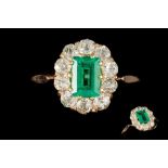 AN EMERALD AND DIAMOND CLUSTER RING, one step cut fine Colombian emerald of 0.