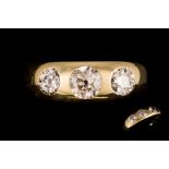 AN ANTIQUE THREE STONE DIAMOND RING, the old cut diamonds gypsy set in 18ct yellow gold.